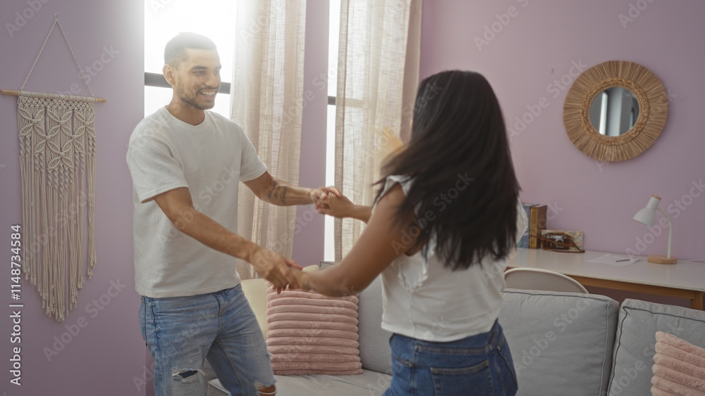 Fototapeta premium Happy couple dancing together in a cozy living room with pink walls and natural light, showcasing love and connection indoors.