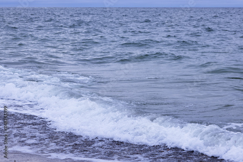 Rolling of a foam wave on the shore in the North Sea photo