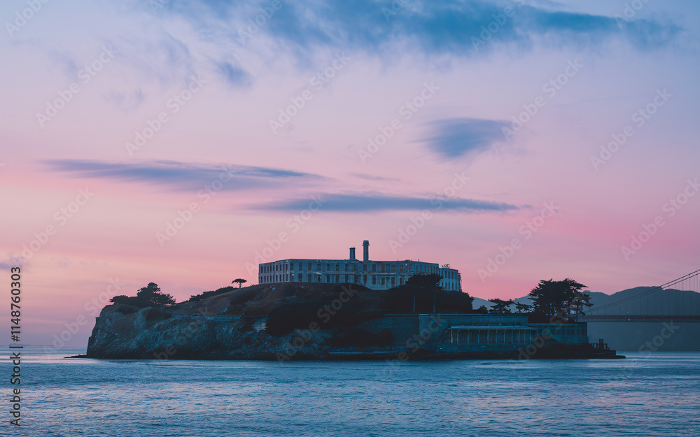 Alcatraz Island at sunset, silhouetted against a pastel sky. Alcatraz Island at sunset, silhouetted against a pastel sky.