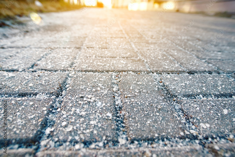 Salt crystals on sidewalk during winter conditions. Excessive winter salt spreading on sidewalks for de-icing, highlighting harmful environmental impact, health risks, and long-term pavement damage.