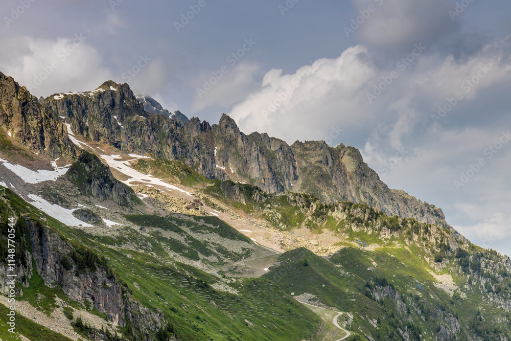 Obraz premium Nasty weather in the Alps. Dark cloudy sky and overcast before the rain and storm. Stormy weather. Snow and rocky summits of the alpine peaks inside the cloud. Aiguilles du Chamonix in autumn 