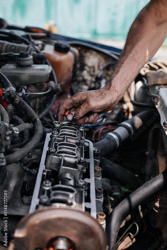 A worker repairs the cylinder head of an automobile engine. Oil removal valve. Car repairs. Car service A worker repairs the cylinder head of an automobile engine. Oil removal valve. Car repairs. Car service