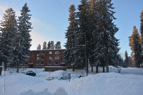 Beautiful winter streets, alleys with roads, cars, cyclists, sidewalks, green fir trees, birches, trees, covered with white, fluffy snow. Infrastructure, Varkaus, Finland.  photo