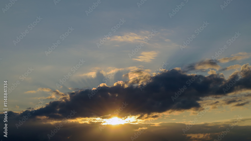 Fototapeta premium Summer evening sky in the picturesque clouds, lit by the rays of the setting sun.
