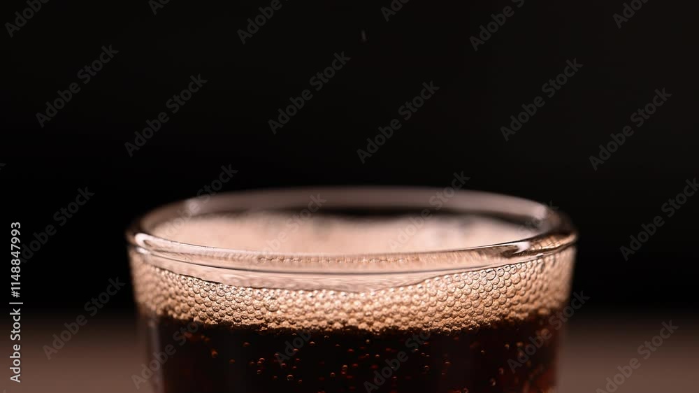 Brown Sweet Sparkling Water is Poured into a Glass. Fizzing cola is Pouring into a glass. Refreshing tasty cola drink. Brown Sweet Sparkling Water is Poured into a Glass. Fizzing cola is Pouring into a glass. Refreshing tasty cola drink.