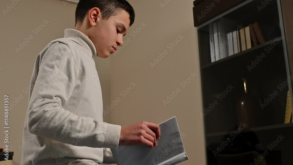 Young boy reading a book in a calm study room setting Young boy reading a book in a calm study room setting