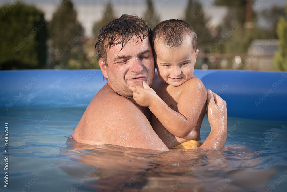Couple of man and baby cooling during hot day in swimming pool on garden Couple of man and baby cooling during hot day in swimming pool on garden