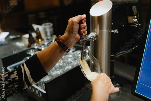 Photography The hands of an elderly woman pours draft beer into a glass.