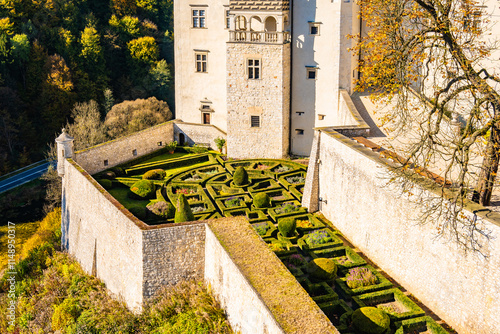 View of Pieskowa Skala castle gardens in park with autumn fall colors of trees in Ojcow National Park, Poland
