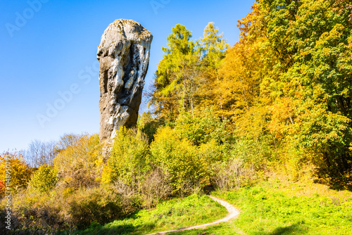 View of Hercules mace rock near Pieskowa Skala castle with autumn fall colors of trees in Ojcow National Park, Poland