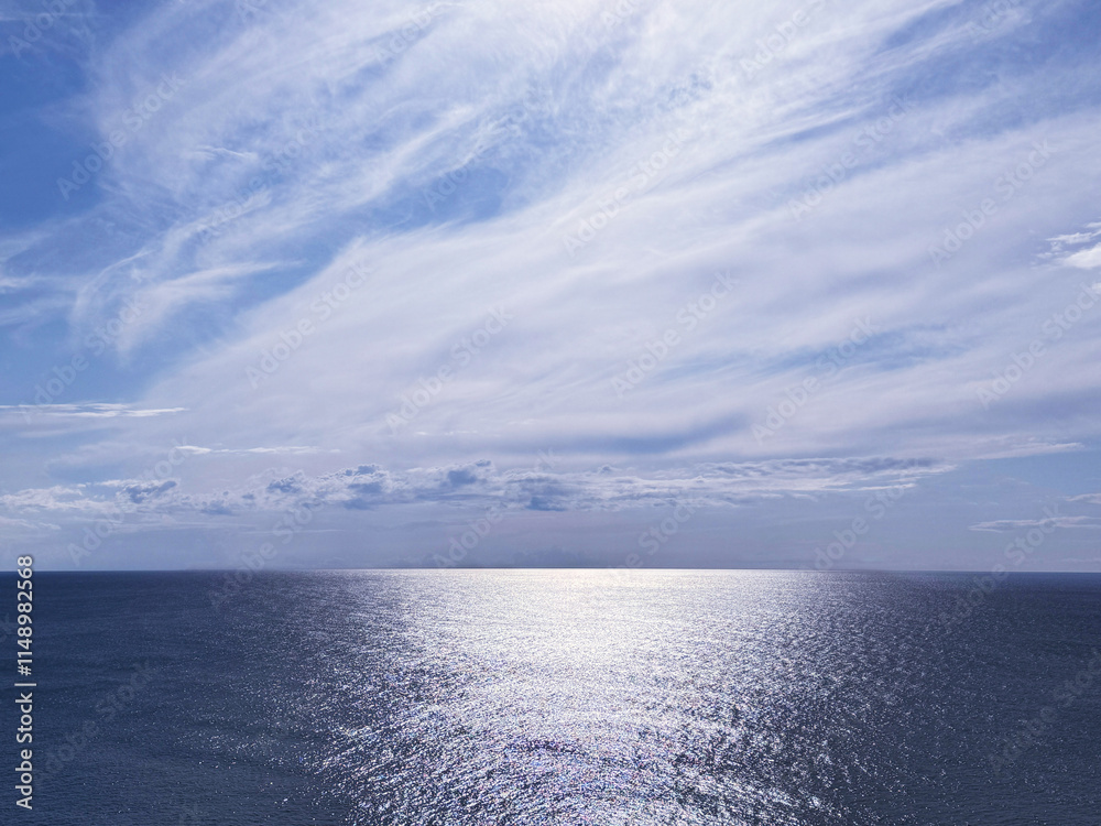Fototapeta premium Glittering ocean and beautiful cloudy sky horizon.