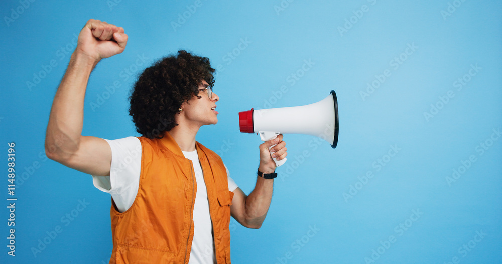 Man, profile and activist with bullhorn in studio for protest, strike or announcement on a blue background. Male person, rebel or march with loudspeaker for awareness, alert or message on space Man, profile and activist with bullhorn in studio for protest, strike or announcement on a blue background. Male person, rebel or march with loudspeaker for awareness, alert or message on space