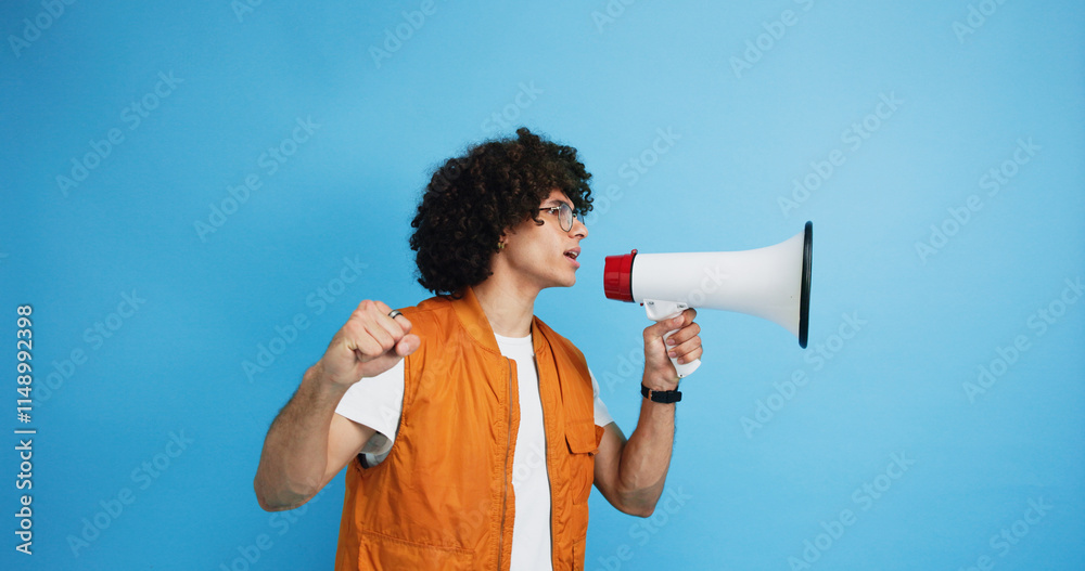 Man, profile and protest with bullhorn in studio for strike, announcement or communication on a blue background. Male person, rebel or march with loudspeaker for awareness, alert or message on space Man, profile and protest with bullhorn in studio for strike, announcement or communication on a blue background. Male person, rebel or march with loudspeaker for awareness, alert or message on space