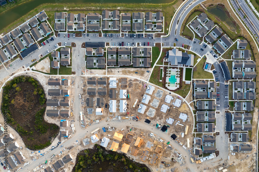 Fototapeta premium Aerial view of unfinished wooden frames of affordable houses under construction. Development of residential housing in American suburbs. Real estate market in the USA