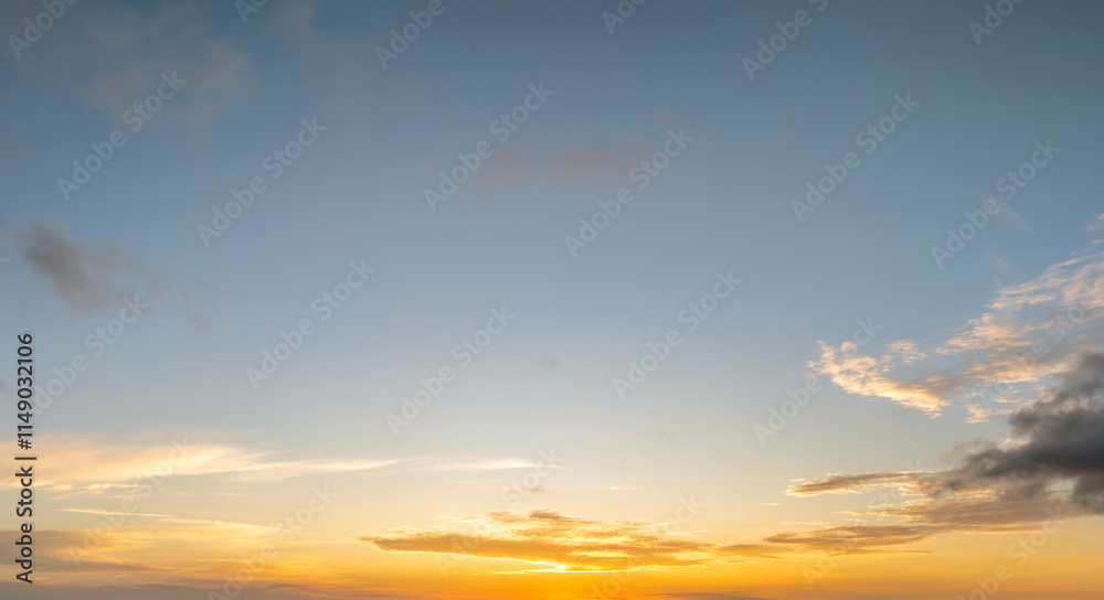 Fototapeta premium Colorful sunset sky with setting sun behind vivid orange and yellow clouds