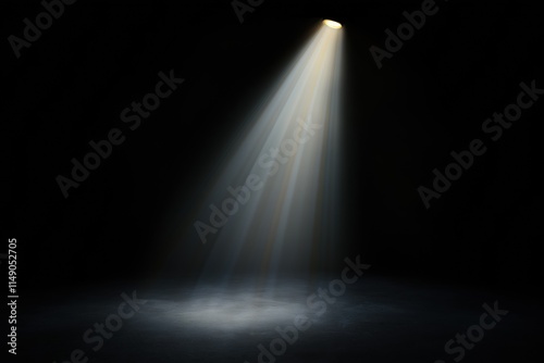 A dark room with a spotlight shining on a spot on the floor. The light is bright and creates a dramatic effect