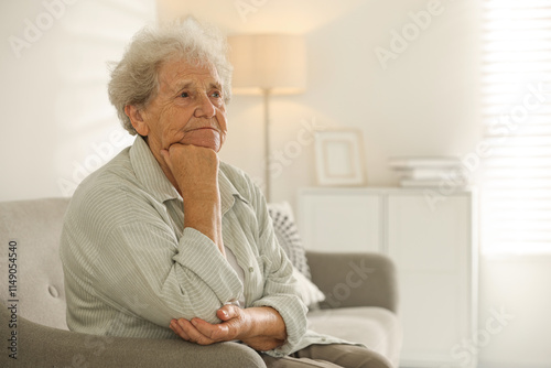 Loneliness concept. Sad senior woman sitting on sofa at home