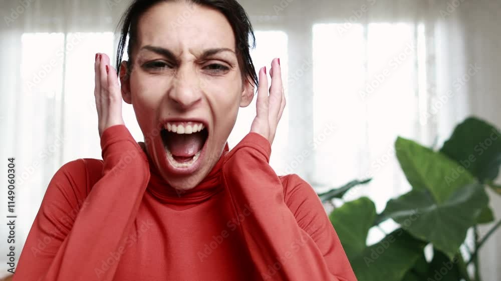 Young woman expressing intense frustration while screaming in slow motion