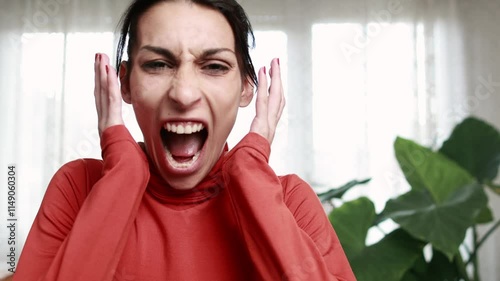 Young woman expressing intense frustration while screaming in slow motion