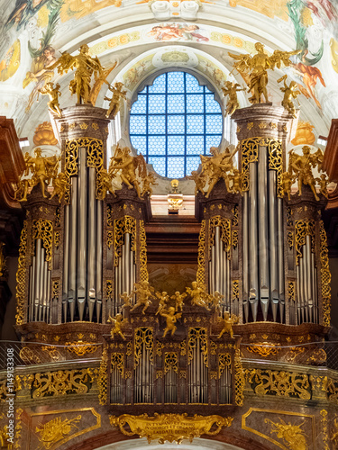 Obraz na płótnie Ornate organ display in a historic church featuring intricate gold detailing and a stained glass window w salonie