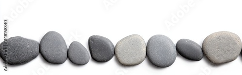 A minimalist arrangement of smooth, gray pebbles lined up in a row against a white background, showcasing their unique shapes and textures.