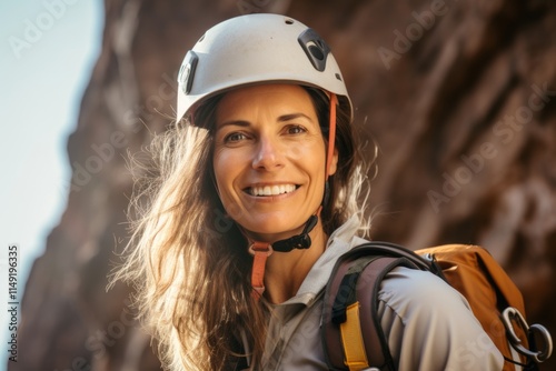 Portrait of a female climber with helmet and backpack in the mountains