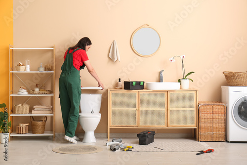 Female plumber fixing toile...