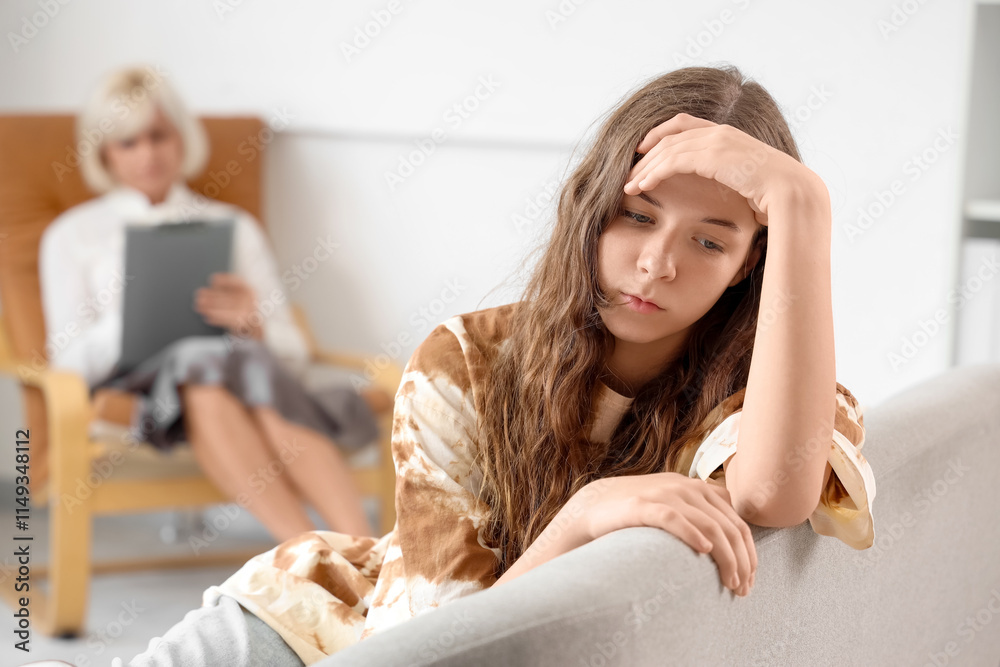 Sad teenage girl sitting at psychologist's office Sad teenage girl sitting at psychologist's office