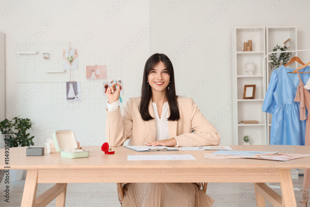 Female wedding planner working at table in office Female wedding planner working at table in office