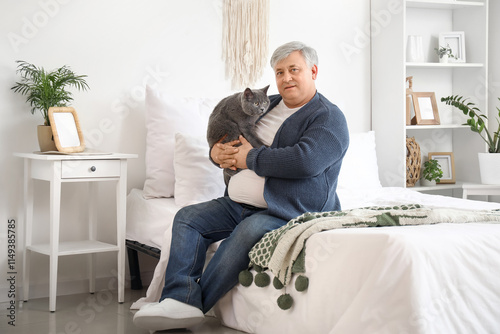Senior man with cute cat in...