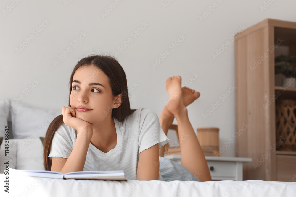 Beautiful young thoughtful woman reading book on bed at home Beautiful young thoughtful woman reading book on bed at home