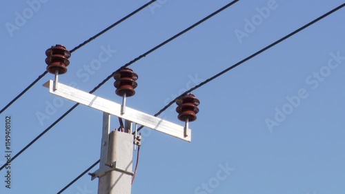 Power lines on background of blue sky close-up. Electricity equipment with copy space. Wires of high voltage in sky. High-Voltage power lines station. High-Voltage Electric Transmission Pylon.