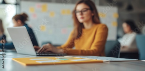 Young Woman Working on Laptop in Bright Office Environment
