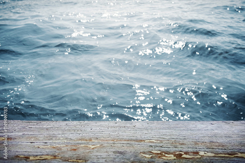 Water surface with wooden table in front photo