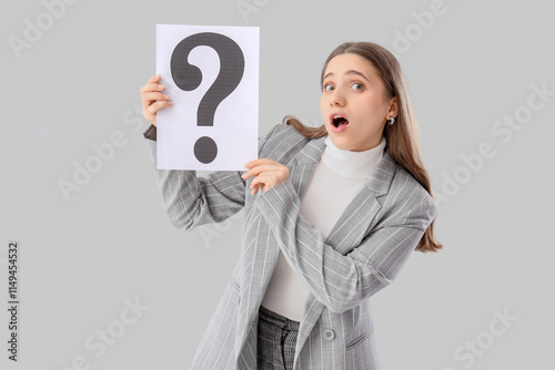 Puzzled businesswoman holdi...