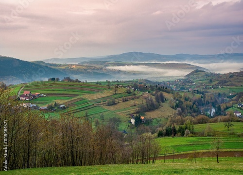 Rural landscape with fields, meadows, small villages, sensitively and ecologically managed landscape, in the background mountains after a storm with fog. photo