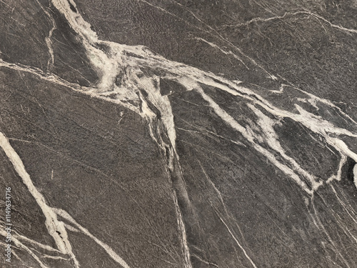 Canvastavla Natural black marble with white veins pattern in rough textured finishes, Black honed marble with diagonal white veining, rough stone texture