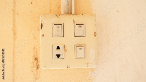 Aged Electrical Switch Plate with Dust and Wear on Wall Surface photo