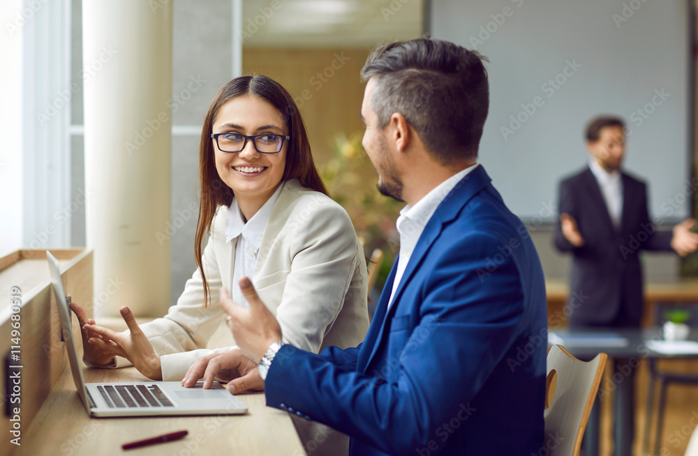 Obraz premium Focused collaboration as entrepreneurs team, a man and a woman, engage in a productive discussion in the office. Business partners work meeting captures the essence of teamwork and communication.