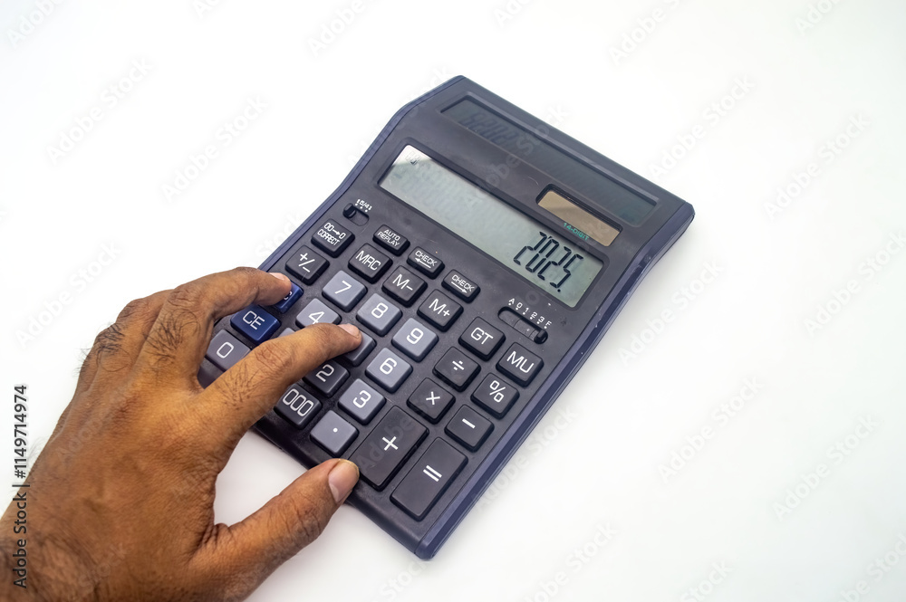 A hand using a calculator with the number 2025 displayed on the screen. The calculator is on a white background A hand using a calculator with the number 2025 displayed on the screen. The calculator is on a white background