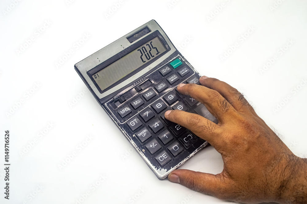 A hand using a calculator displaying the year 2025, symbolizing future financial planning or budgeting. The image highlights the importance of financial foresight A hand using a calculator displaying the year 2025, symbolizing future financial planning or budgeting. The image highlights the importance of financial foresight