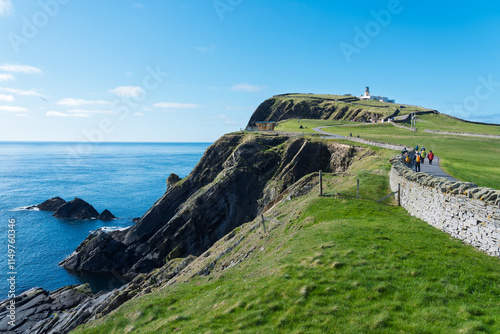 Picturesque coastal walk with cliffs, lighthouse, and panoramic ocean views