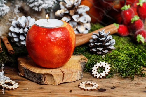 Obraz na płótnie Florist at work: woman shows how to make a Christmas decoration with apple, candle and branches of fir. Step by step, tutorial. w salonie