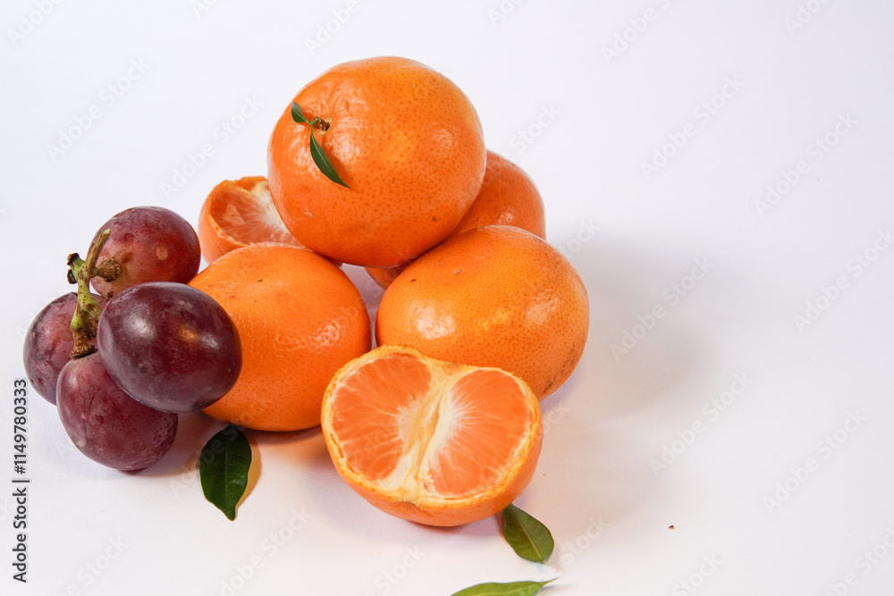 The concept of Tangerine or Mandarin orange with Grapes and Pears on a white background is suitable for design needs, as an illustration for articles about fruits and others.