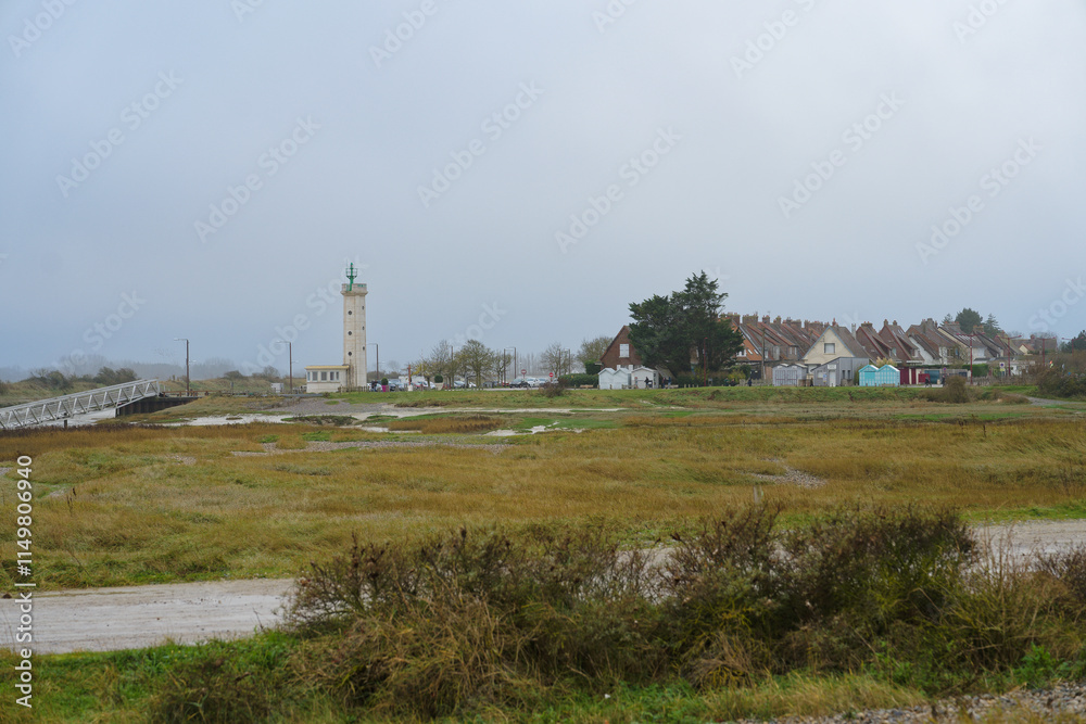 Scenic view of a coastal village with a lighthouse and bridge under overcast skies in the early morning Scenic view of a coastal village with a lighthouse and bridge under overcast skies in the early morning