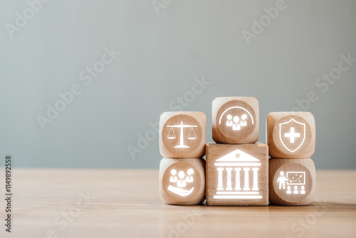 Wooden blocks symbolizing social policy elements like justice, healthcare, education, and community on a wooden table. photo