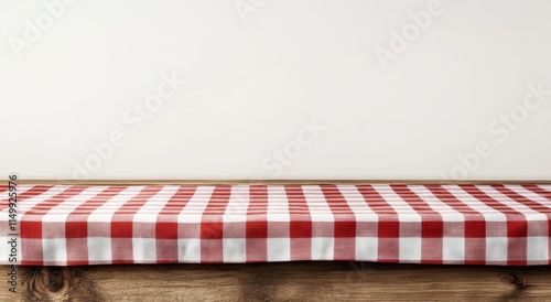 Red checkered tablecloth on wooden table against white wall. (3) photo