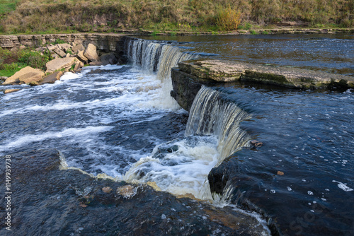 Waterfall on the Tosna River on a sunny October day. Leningrad Region, Russia photo