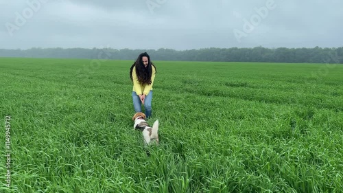 4k Girl training with a dog in a green field.