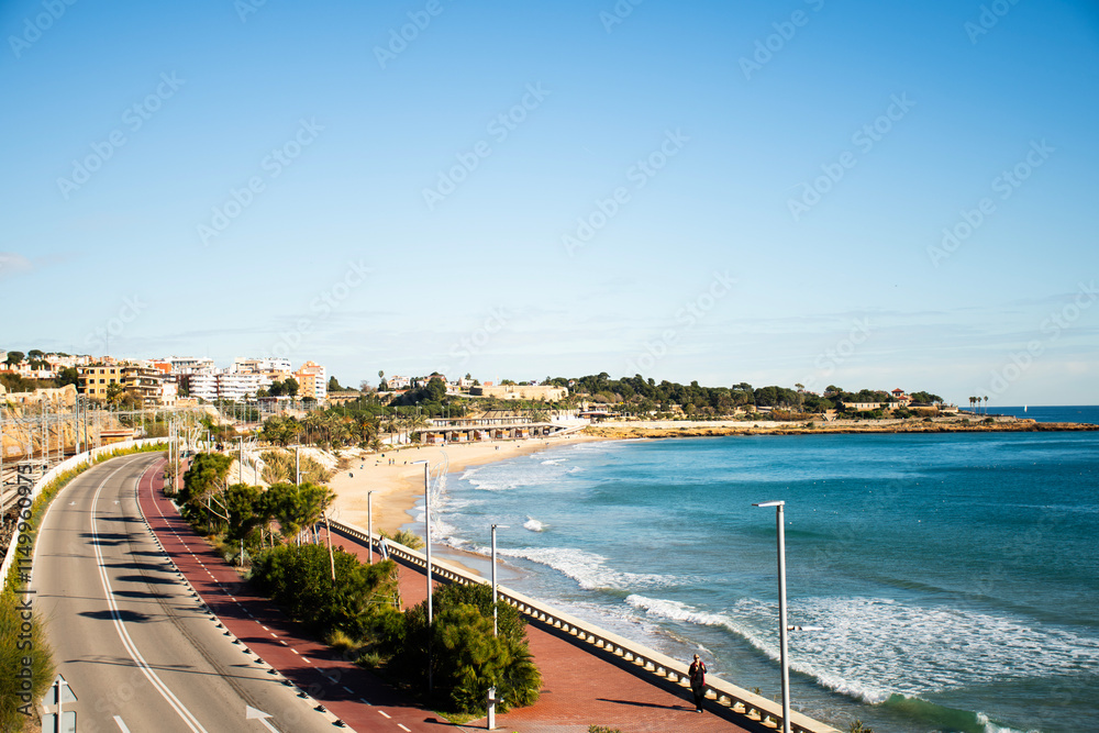 Obraz premium beach with history of tarragona on the coast of the mediterranean sea in spain holidays tourist destination hotels and buildings facing the sea and historic ruins